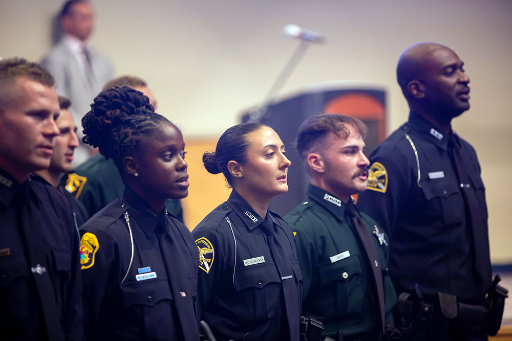male and female graduates on law enforcement academy wearing their uniforms