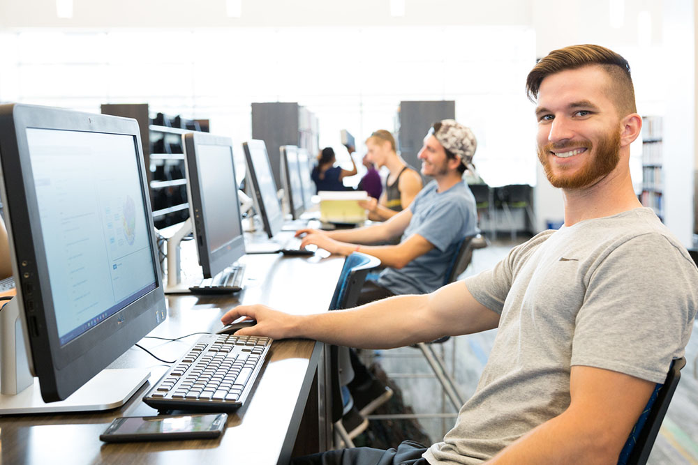 male student seated at a computer lab