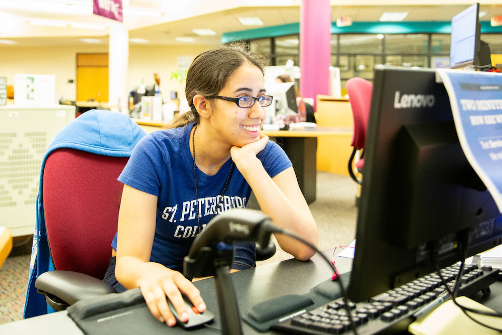 female student seated in front of a computer monitor