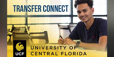 A student, smiling at the camera, sitting at a common area table.