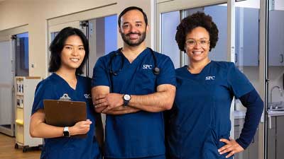 2 female and 1 male nursing students smiling at the camera
