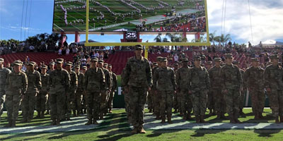 Army batallion in formation in front of the Raymond James stadium screen