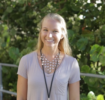 female student wearing a lavendar t-shirt and with a badge around her neck