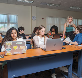 SPC students seated at their work tables with laptops open
