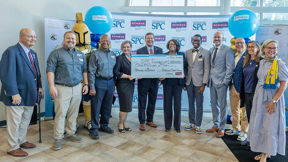 group of people in business attire hilding a giant check