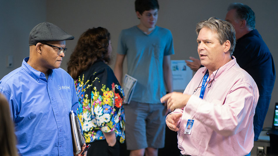 group of people standing listening to a college advisor