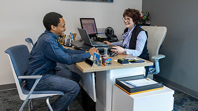 a student talking with an advisor across a desk
