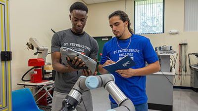 two male students working on robotics equipment