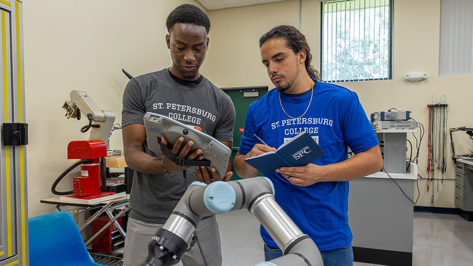 two male students working on robotics equipment