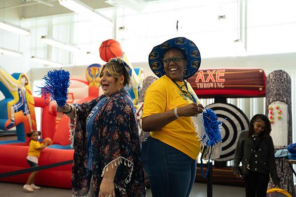 two women dressed in yellow shirts playing games at SPC Day 2025