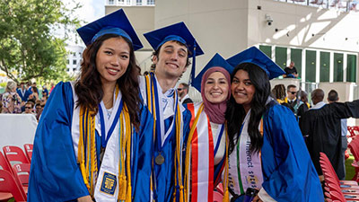 four SPCHS students in graduation caps and gowns smiling