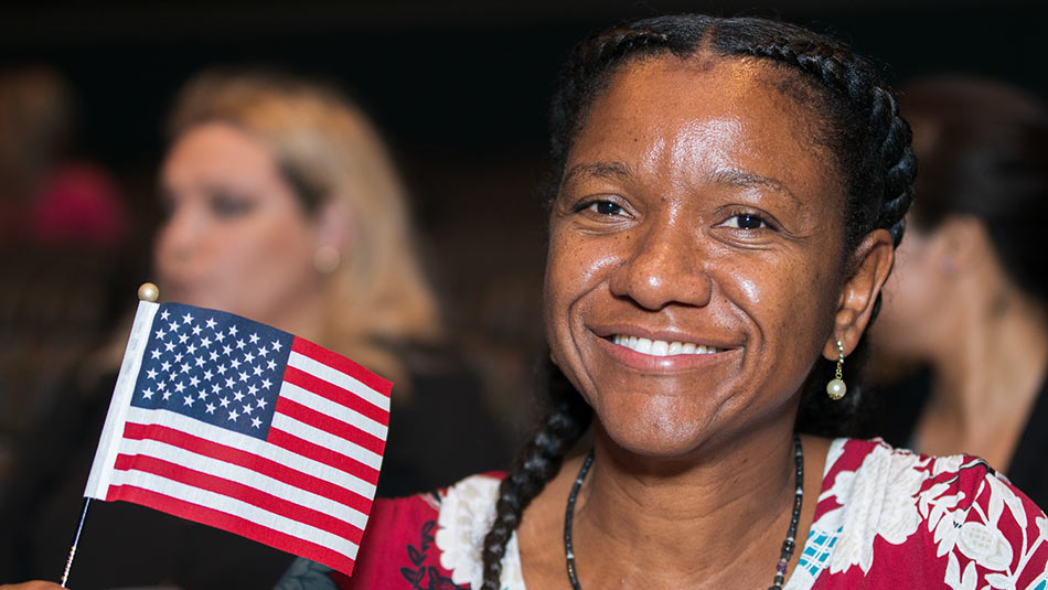 a woman holds an american flag with a big smile on her face