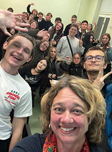 Professor Shelbey Rosengarten taking a selfie with a group of students