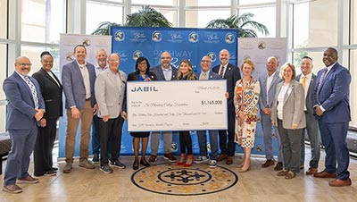 A group of people from Jabil and St. Petersbug College holding a giant donation check