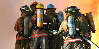 portrait of firefighters fighting huge orange flames
