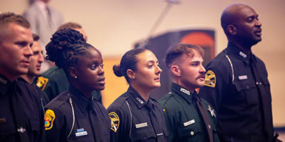 portrait of five newly hired police officers in uniform