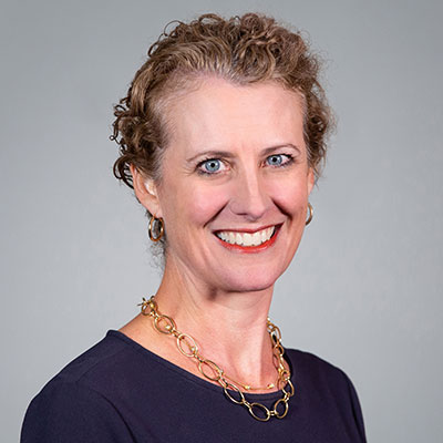 Portrait of Katherine Cole, wearing a blue blouse and gold necklace.