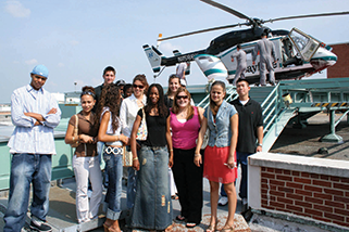 Summer of Success students standing in front of a helicopter