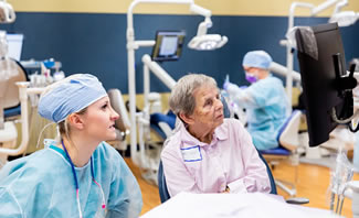 a professor observing a dental hygiene student in the lab