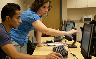 a professor instructing a student at his computer