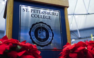 a photo of the SPC podium and seal surrounded by flowers at a graduation event
