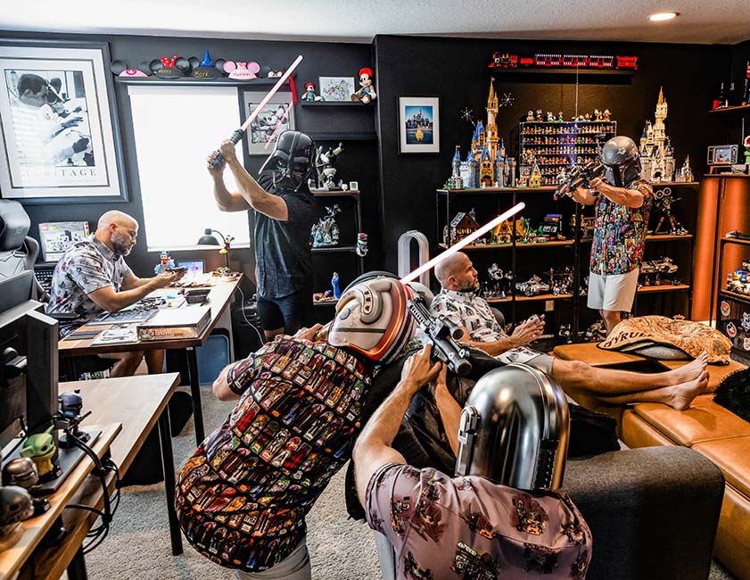 Student digital media project for advanced digital image editing. A man is shown in six different poses in a room packed with nostalgic video game and movie paraphernalia.