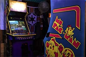 Two vintage video games in an arcade, the one one the right is Ms. Pacman. Two vintage video games in an arcade, the one one the right is Ms. Pacman.