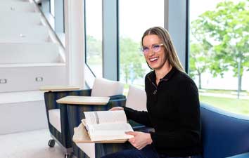 female student in a black sweater smiling seated at SPC's Gibbs campus