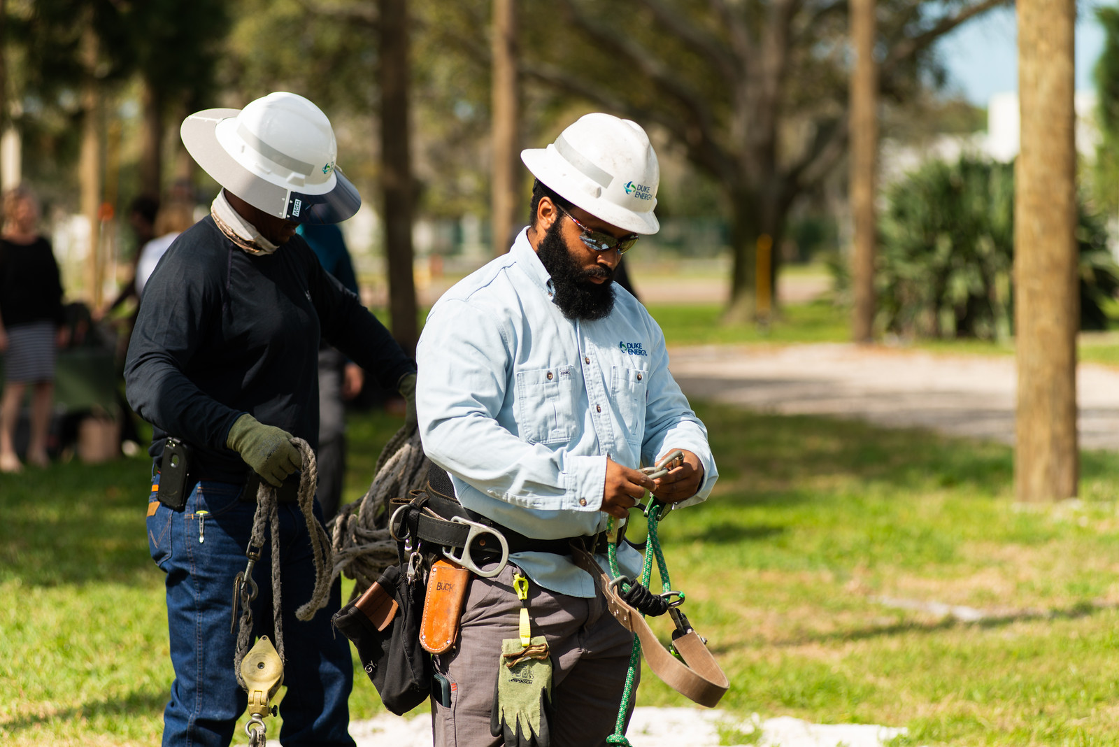 two line workers preparing their equipment