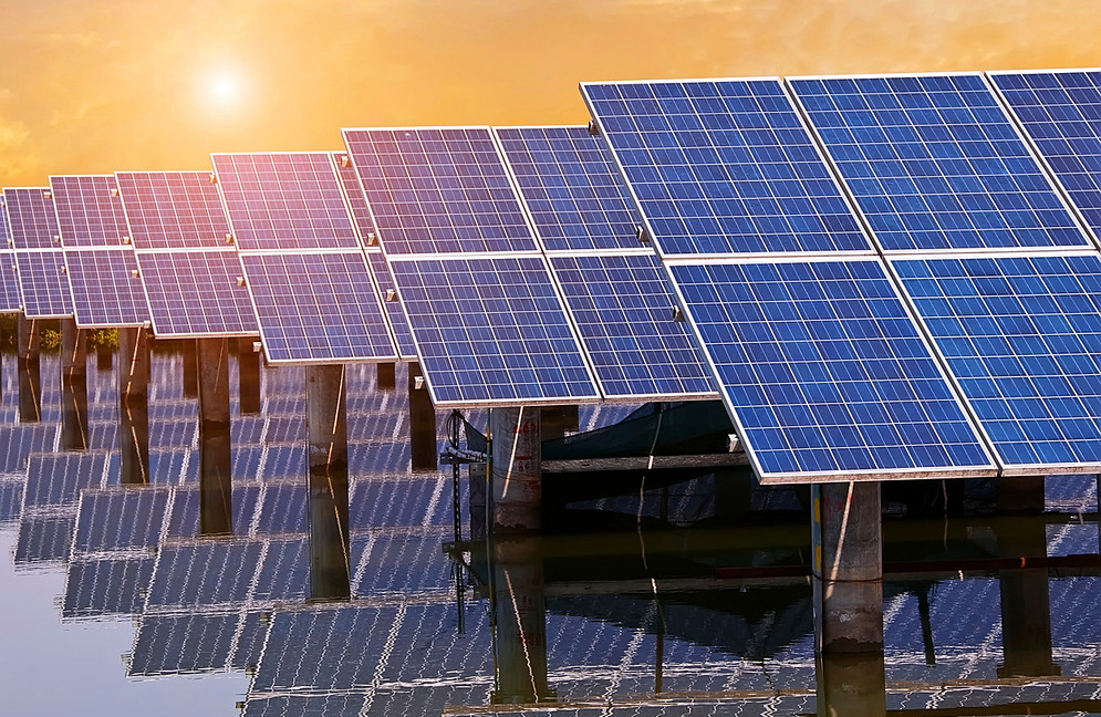 the sun rising behind a large solar panel array 