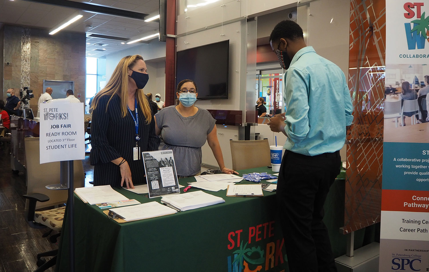 An SPC student gets information from the Saaint Pete Works booth at the 2021 Midtown Center Job Fair