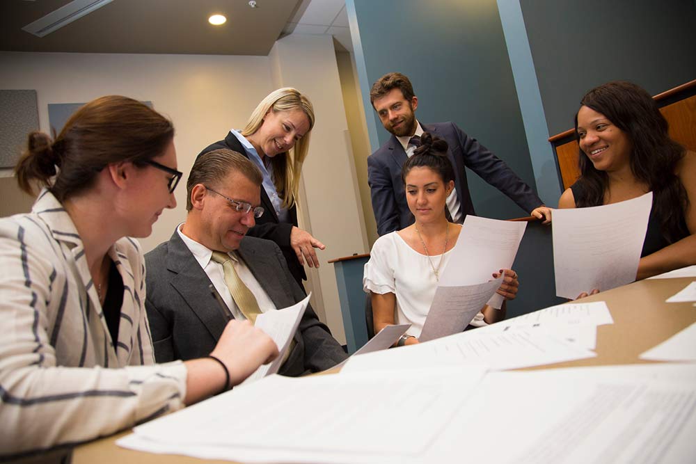 group of paralegal students sitting around a table holding briefs