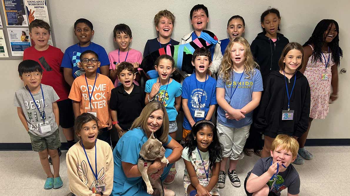 group of kids in shorts and t-shirts smiling and laughing during a summer camp at SPC