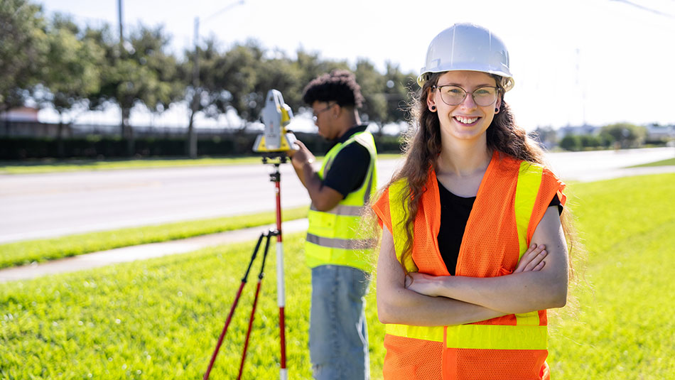 male and female field techicians taking measurements with a surveyor