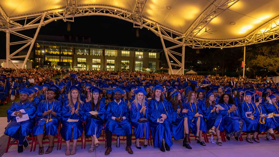 SPC graduates in graduation robes seated under the roof of the BayCare Sound