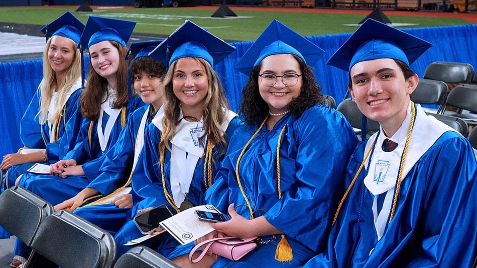 group of six collegiate high school graduates attending graduation ceremonites