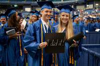 2 SPC graduates posing for a photo with a sign saying We Did It