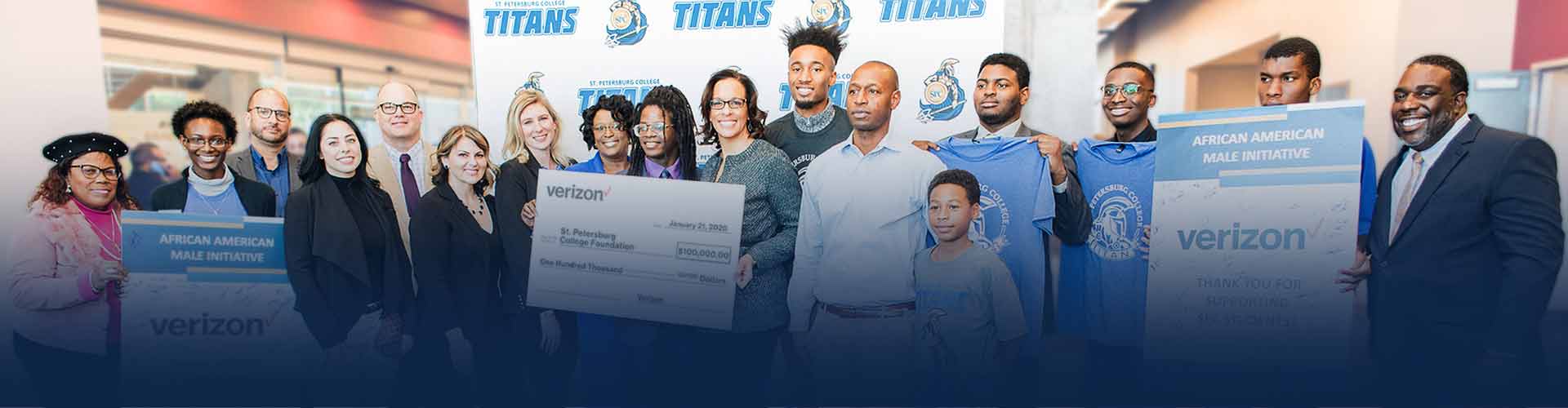 A group photo of the Verizon grant award for the African American Male Initiative, including Verizon and SPC students and staff in front of an SPC Titans backdrop..