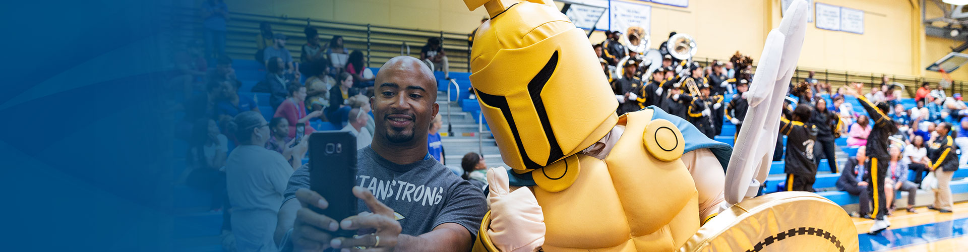 Male SPC student taking a selfie with Titus the Titan mascot